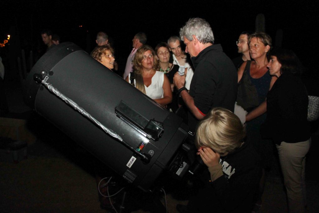 un animateur expliquant ce que les gens observent à travers les télescopes